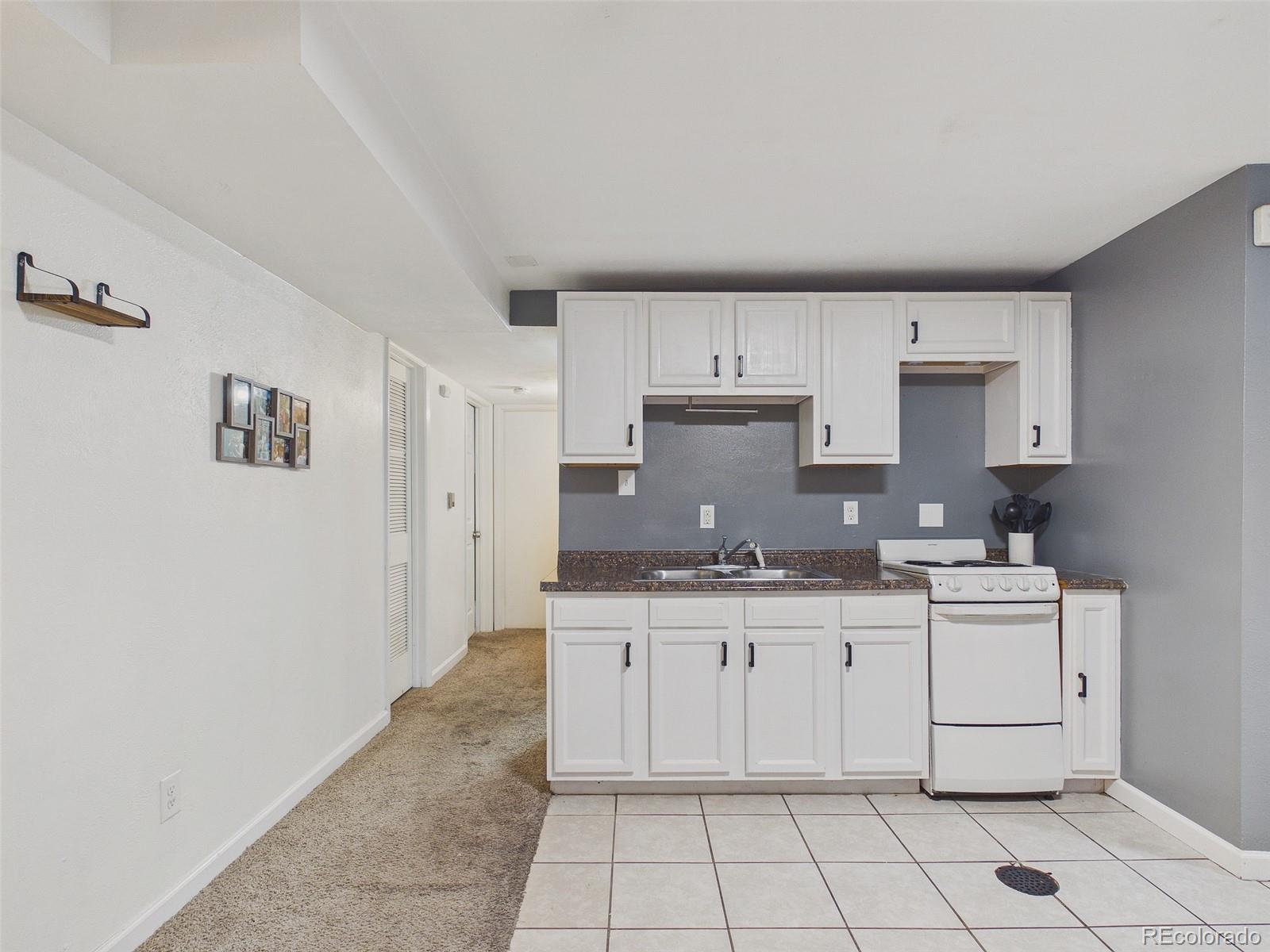 3358 Pontiac Street Denver, CO 80207 - Photo 16 of 26 a kitchen with stainless steel appliances a sink stove and cabinets