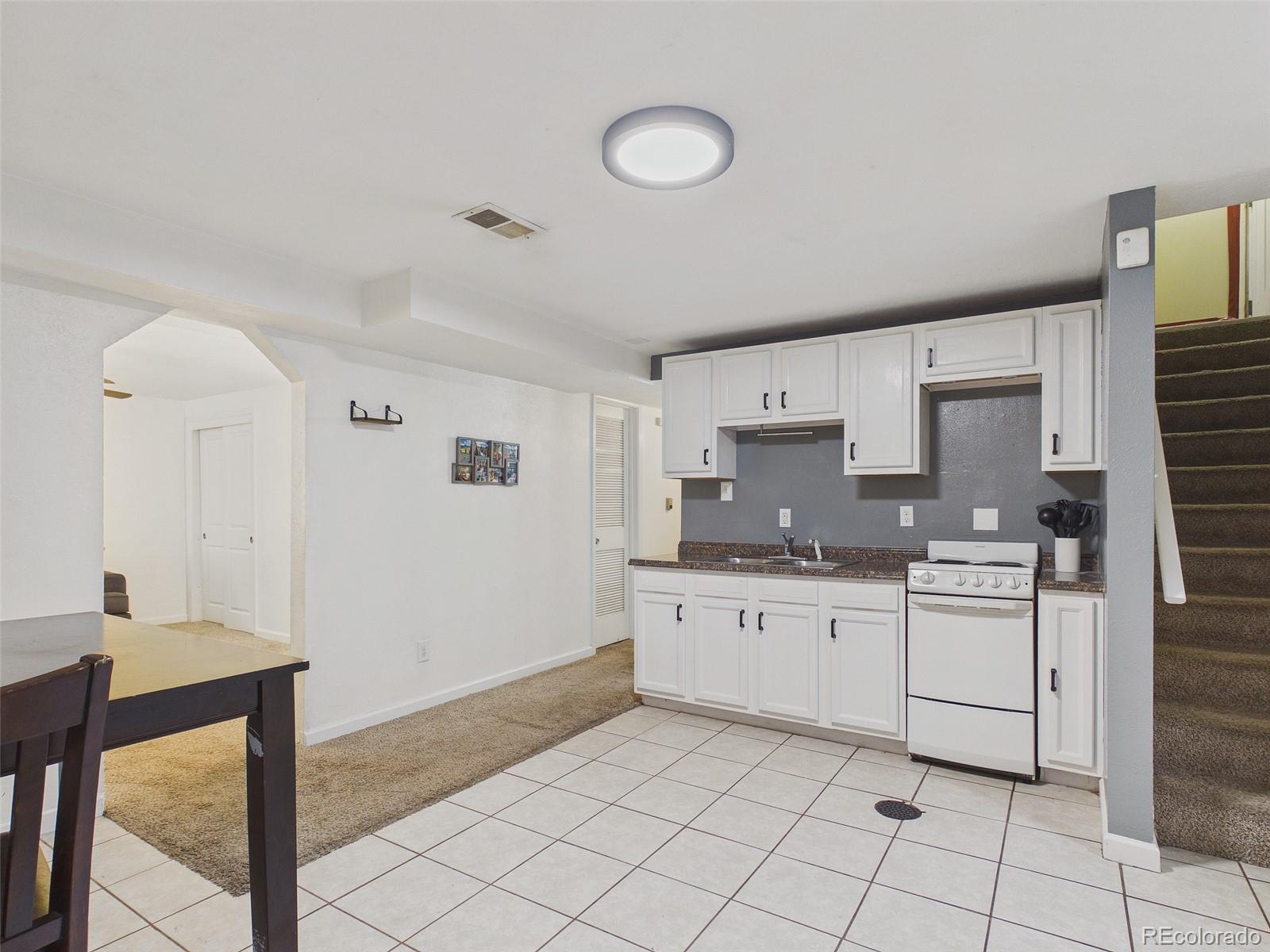 3358 Pontiac Street Denver, CO 80207 - Photo 17 of 26 a kitchen with granite countertop white cabinets and appliances