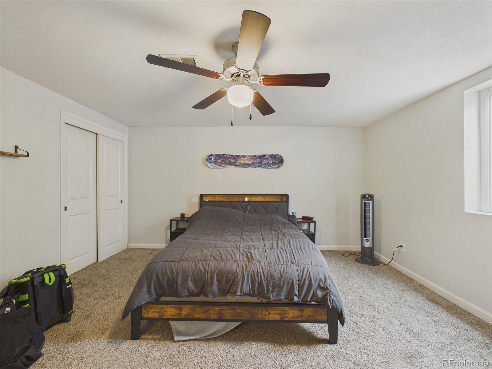3358 Pontiac Street Denver, CO 80207 - Photo 18 of 26 a bedroom with a bed and a chandelier