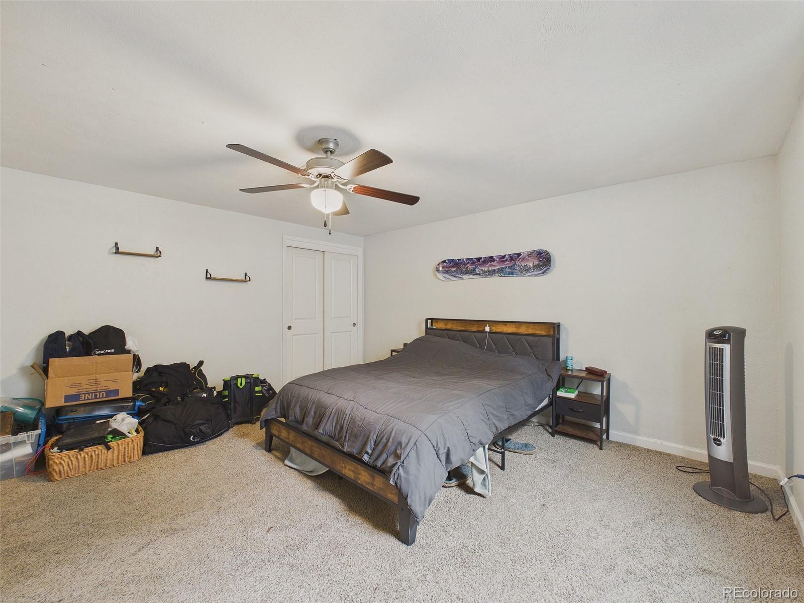3358 Pontiac Street Denver, CO 80207 - Photo 19 of 26 a bedroom with a bed and a ceiling fan