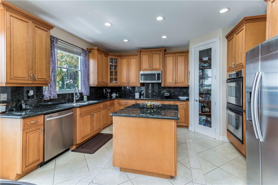 4185 Southwest 186th Way Miramar, FL 33029 - Photo 25 of 92 a kitchen with stainless steel appliances granite countertop a refrigerator a stove a sink and a microwave