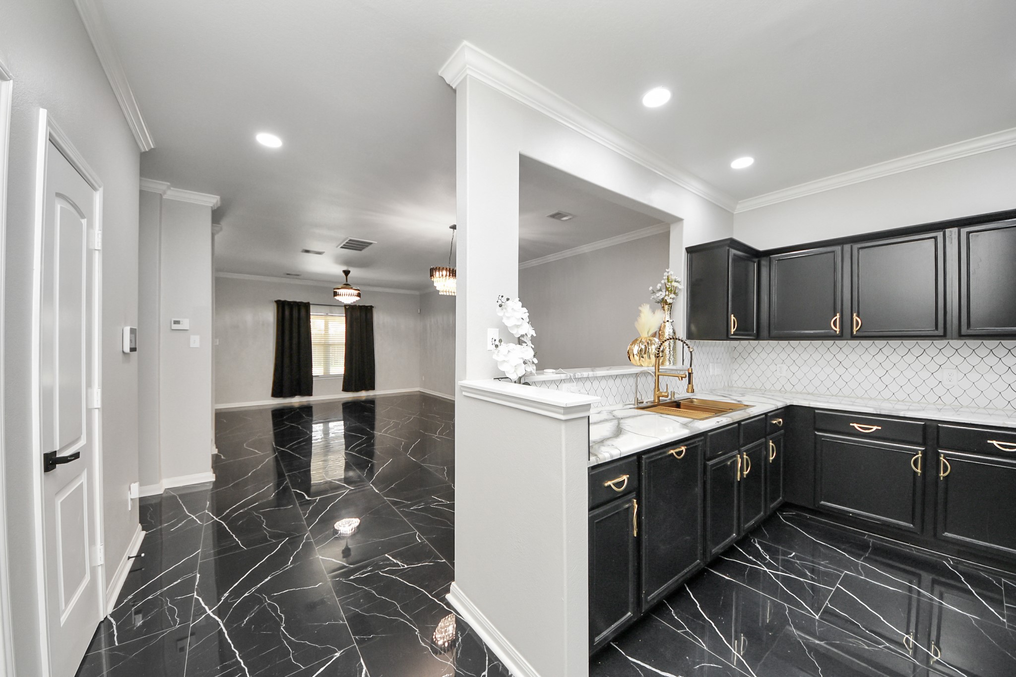 6931 Primrose Road Baytown, TX 77521 - Photo 6 of 50 Modern kitchen with black cabinetry, marble counters, and open flow into dining area.