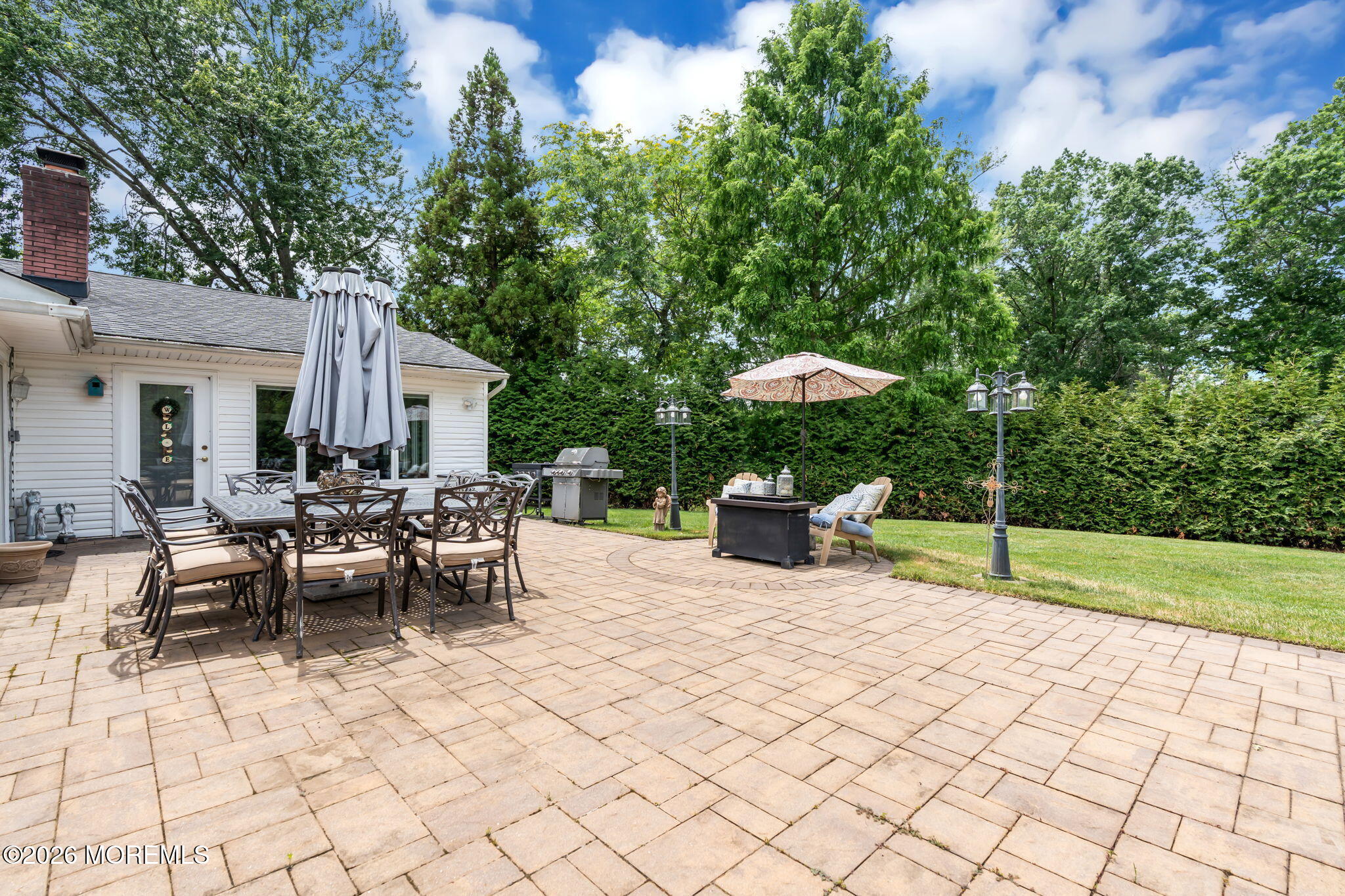 8 Owens Road Marlboro, NJ 07746 - Photo 34 of 39 a view of a patio with table and chairs potted plants and a large tree