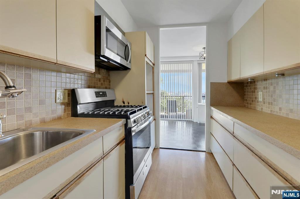 1 Horizon Road, Unit 609 Fort Lee, NJ 07024 - Photo 21 of 40 a kitchen with stainless steel appliances granite countertop a sink and a stove