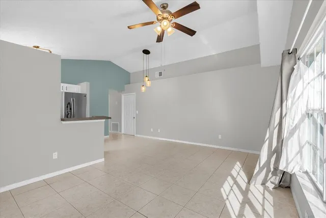 an empty room with windows and fan