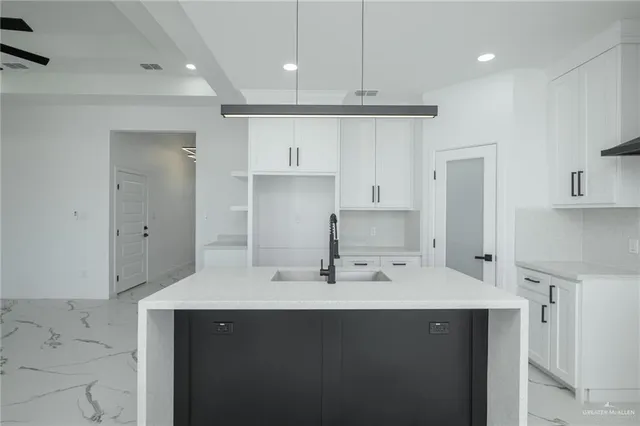 a kitchen with kitchen island a sink stainless steel appliances and cabinets