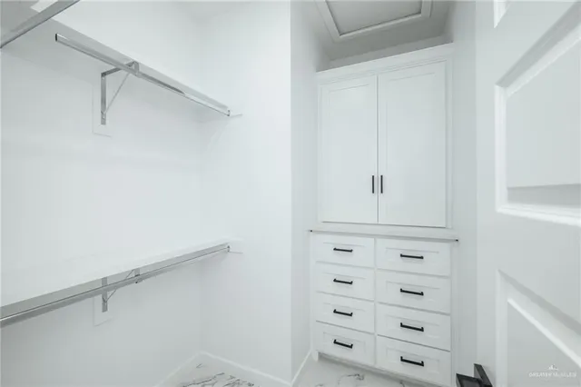 a view of walk in closet with empty racks