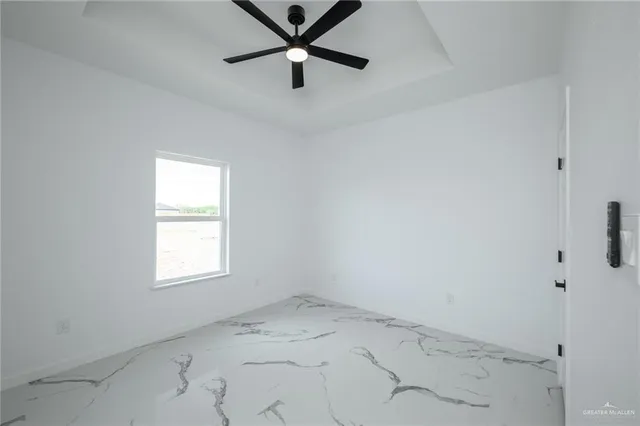 an empty room with a window and a fan