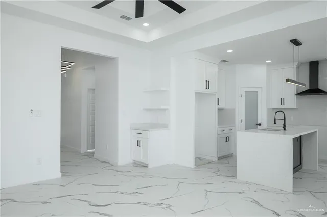 a view of a kitchen with white cabinets and stainless steel appliances