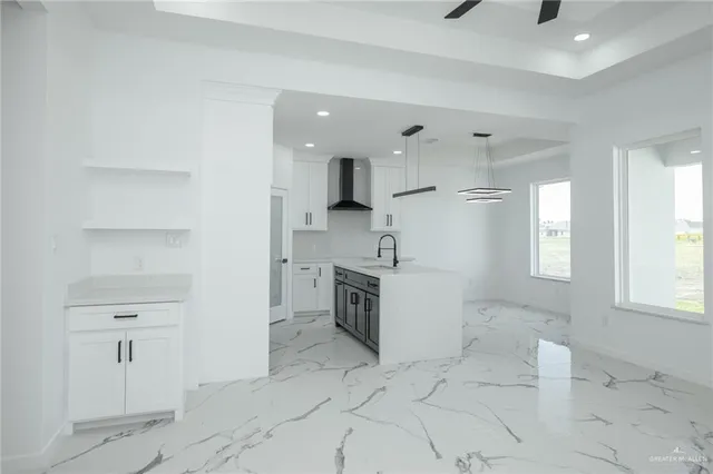 a large white kitchen with a stove a sink dishwasher and a refrigerator