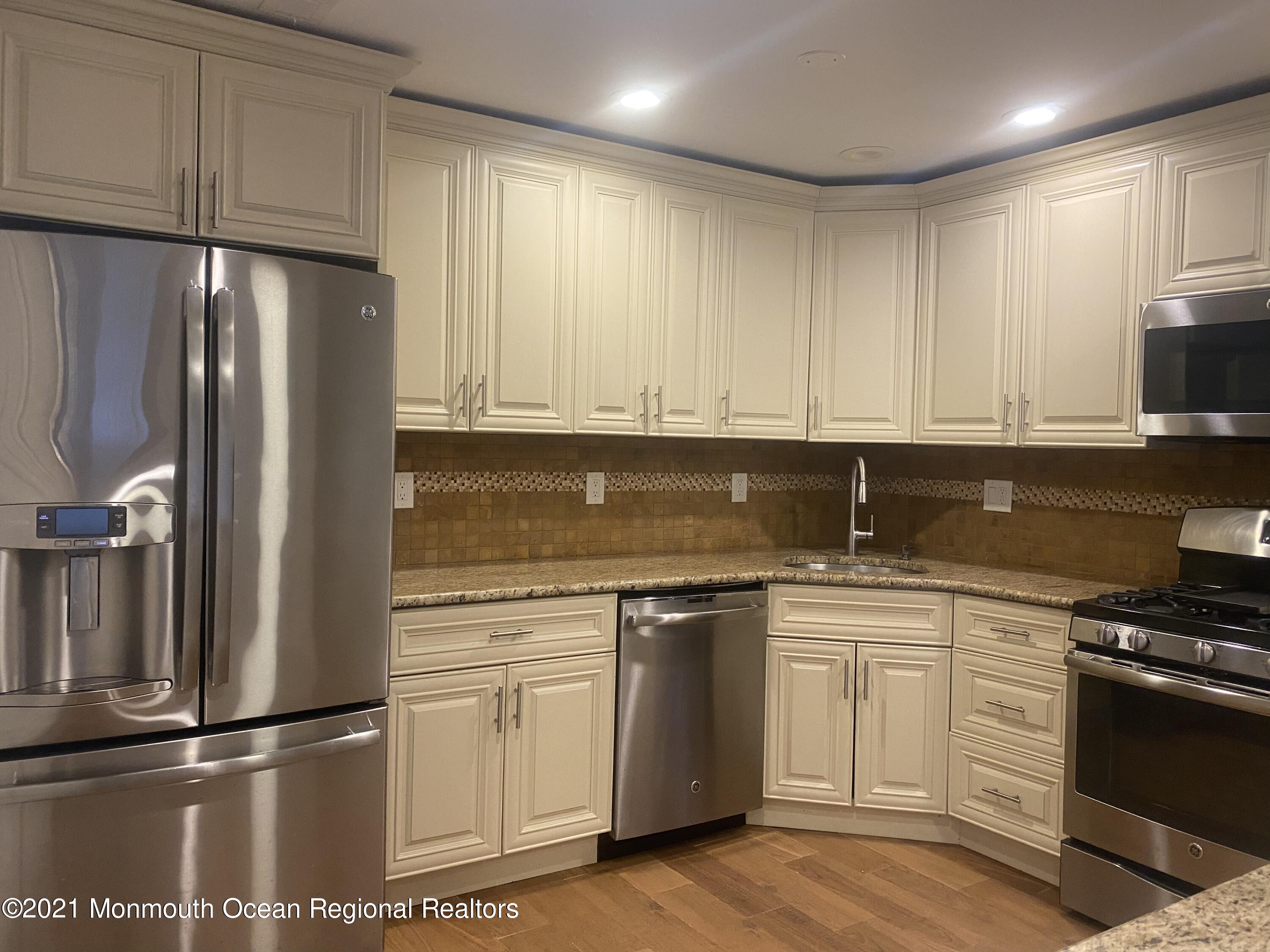 506 Harding Road, Unit 3 Freehold, NJ 07728 - Photo 1 of 18 a kitchen with granite countertop a refrigerator sink and cabinets