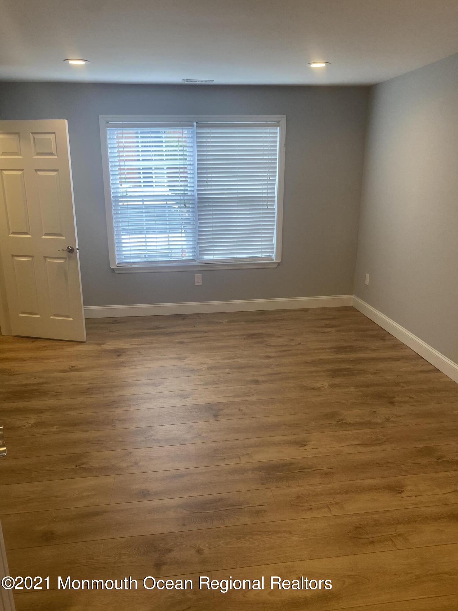 506 Harding Road, Unit 3 Freehold, NJ 07728 - Photo 11 of 18 an empty room with wooden floor and windows