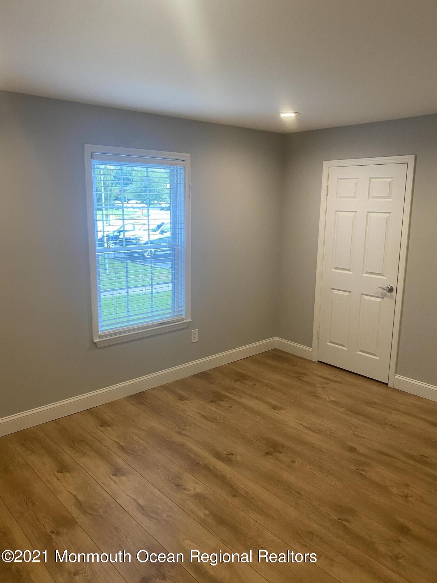 506 Harding Road, Unit 3 Freehold, NJ 07728 - Photo 13 of 18 an empty room with wooden floor and windows