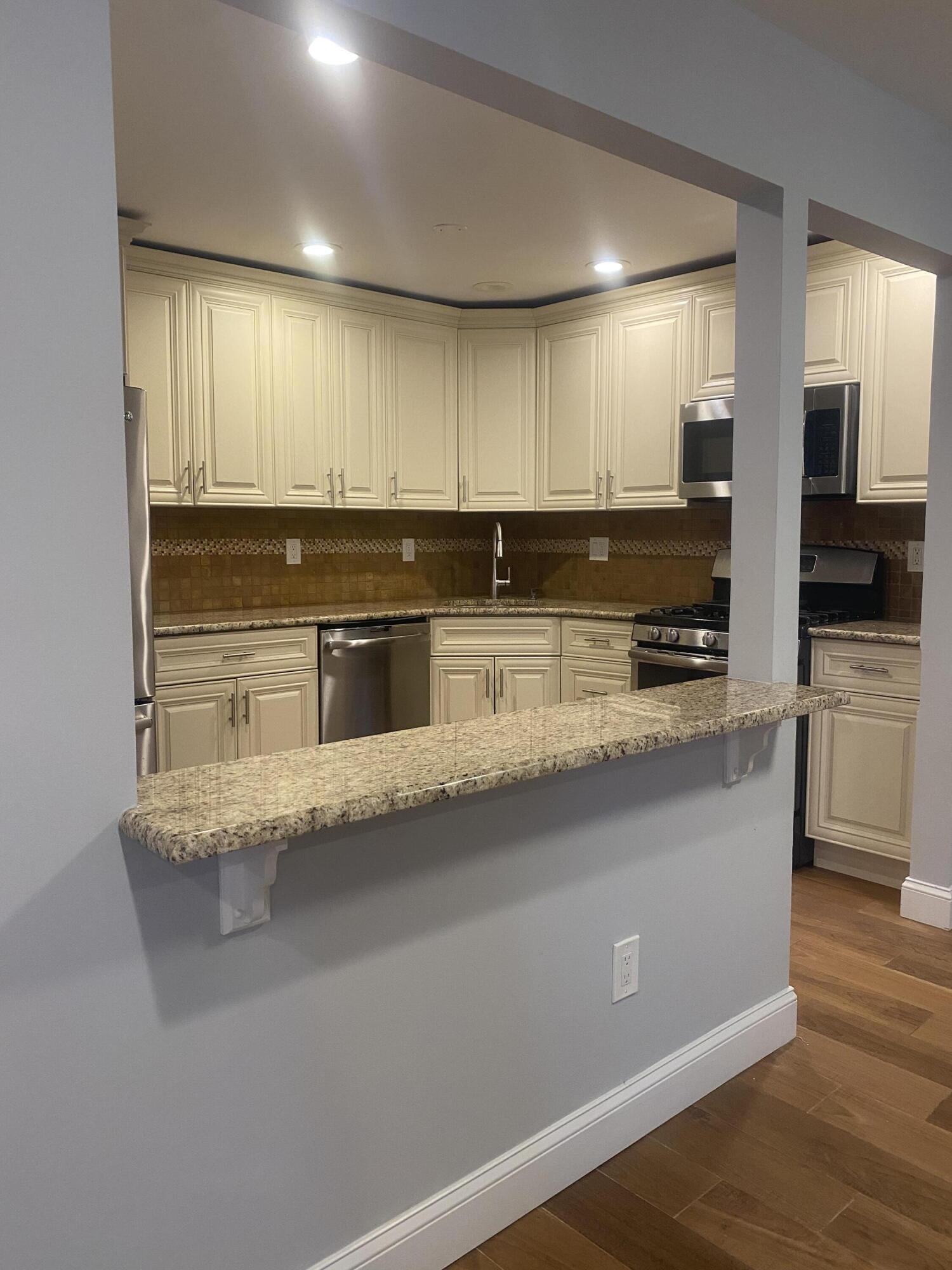 506 Harding Road, Unit 3 Freehold, NJ 07728 - Photo 4 of 18 a kitchen with stainless steel appliances granite countertop a stove a sink and a microwave