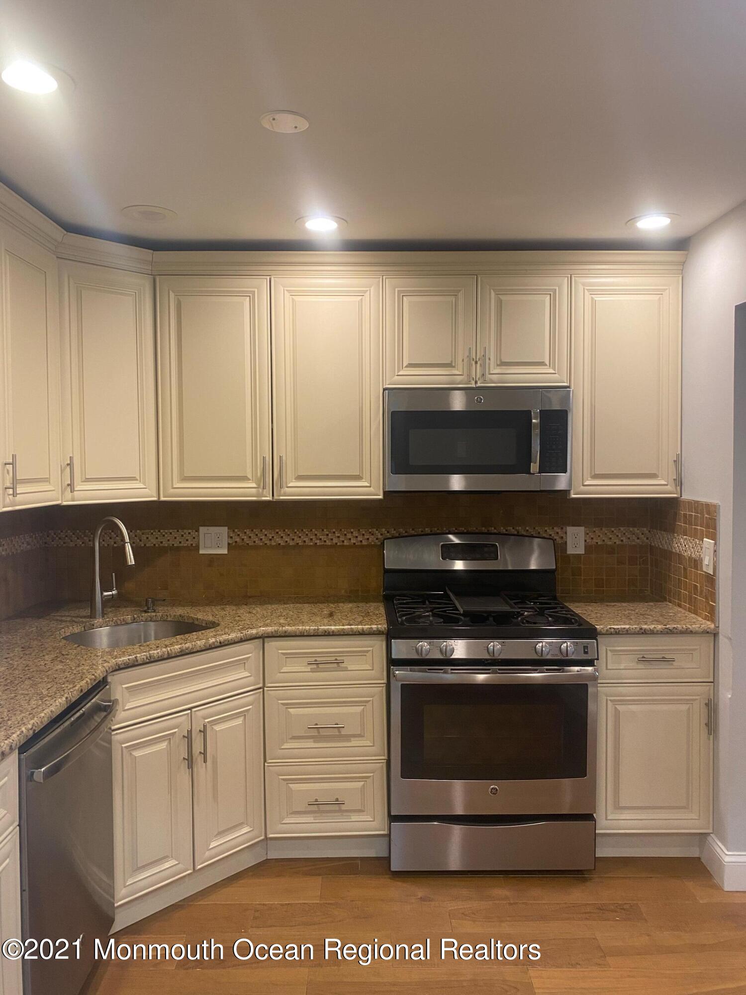 506 Harding Road, Unit 3 Freehold, NJ 07728 - Photo 5 of 18 a kitchen with granite countertop a stove sink and cabinets