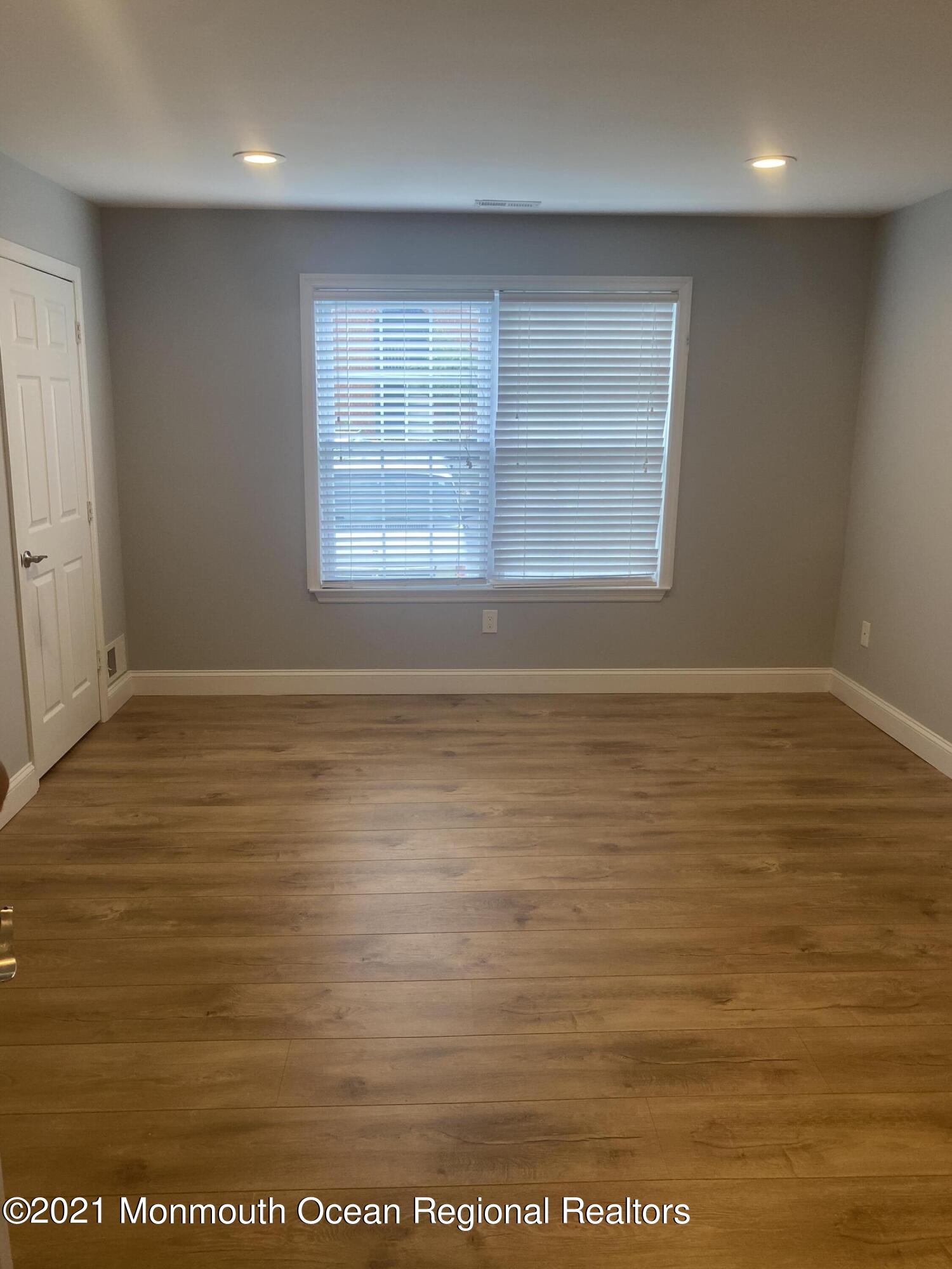 506 Harding Road, Unit 3 Freehold, NJ 07728 - Photo 8 of 18 an empty room with wooden floor and windows