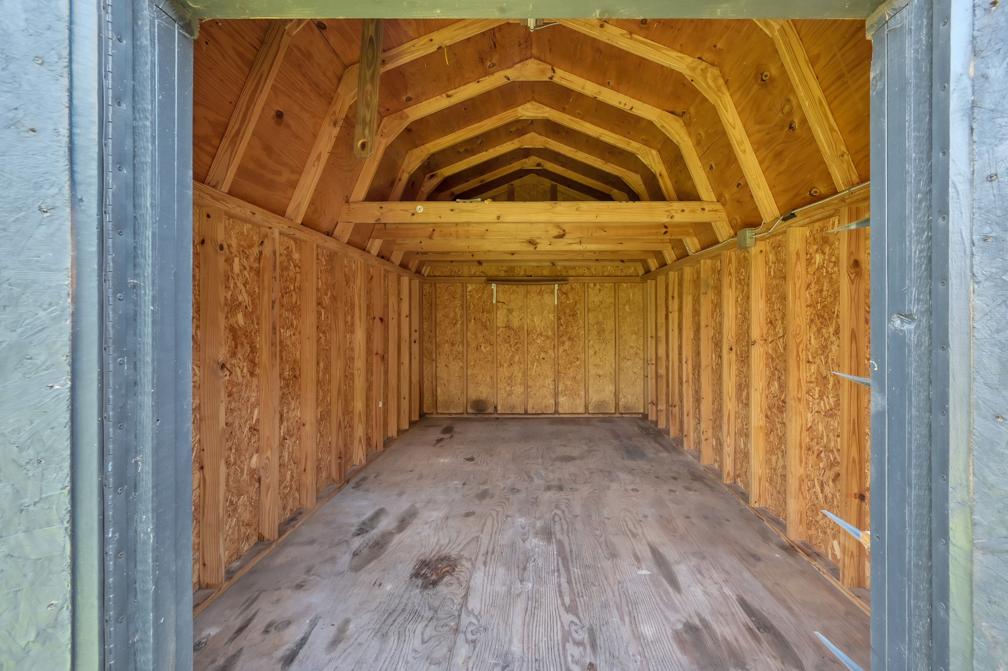 12015 Fallbrook Drive Houston, TX 77065 - Photo 29 of 29 This photo shows the interior of a spacious wooden shed with unfinished walls and a pitched roof, ideal for storage or a workshop.