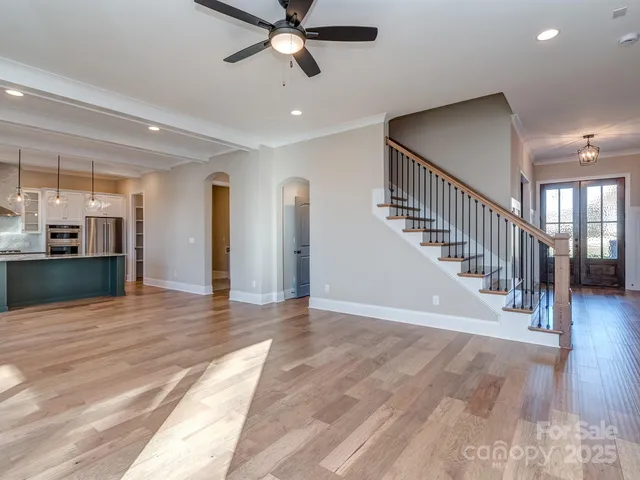 a view of a hallway with wooden floor and staircase