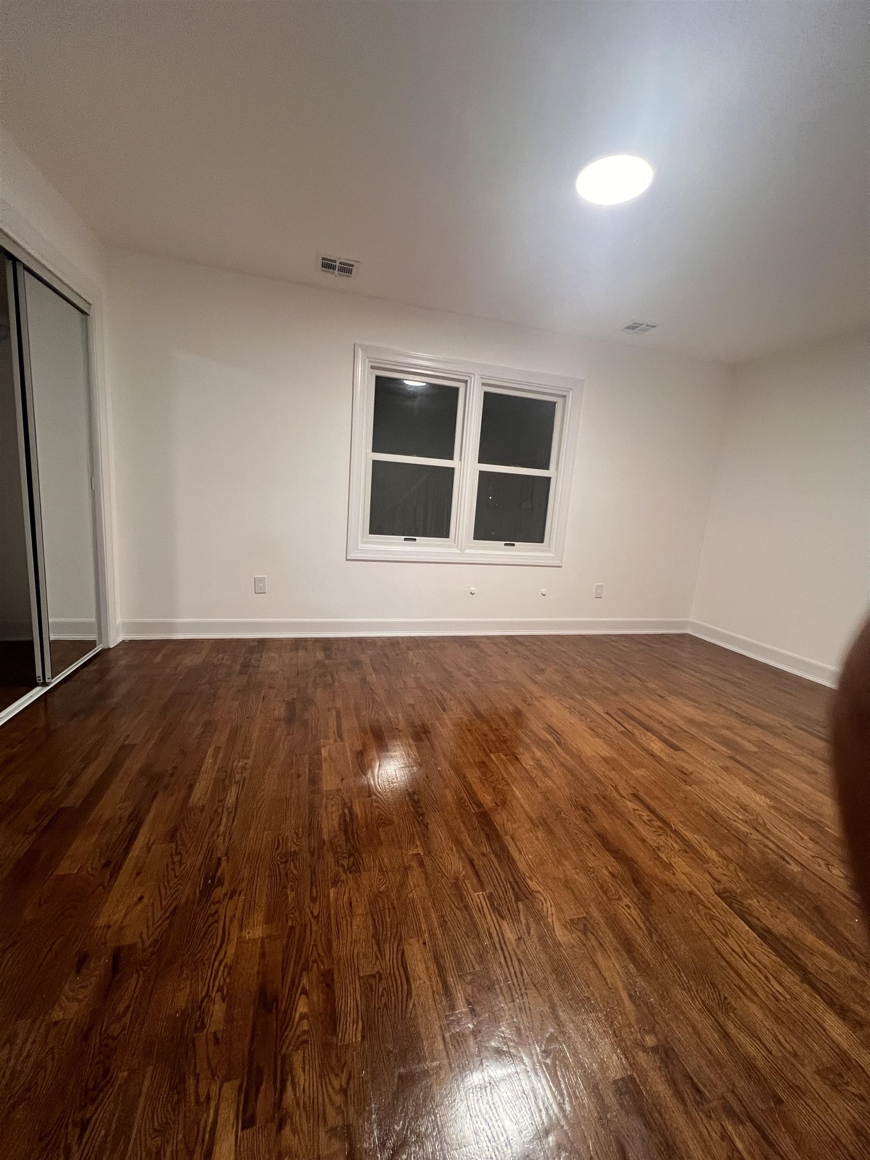 1302 Morris Street Union City, NJ 07087 - Photo 11 of 12 a view of an empty room with wooden floor and a window