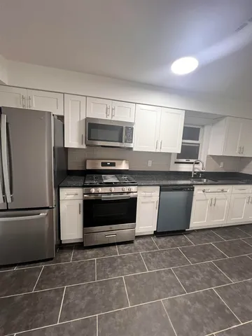 a kitchen with a stove a microwave and a refrigerator