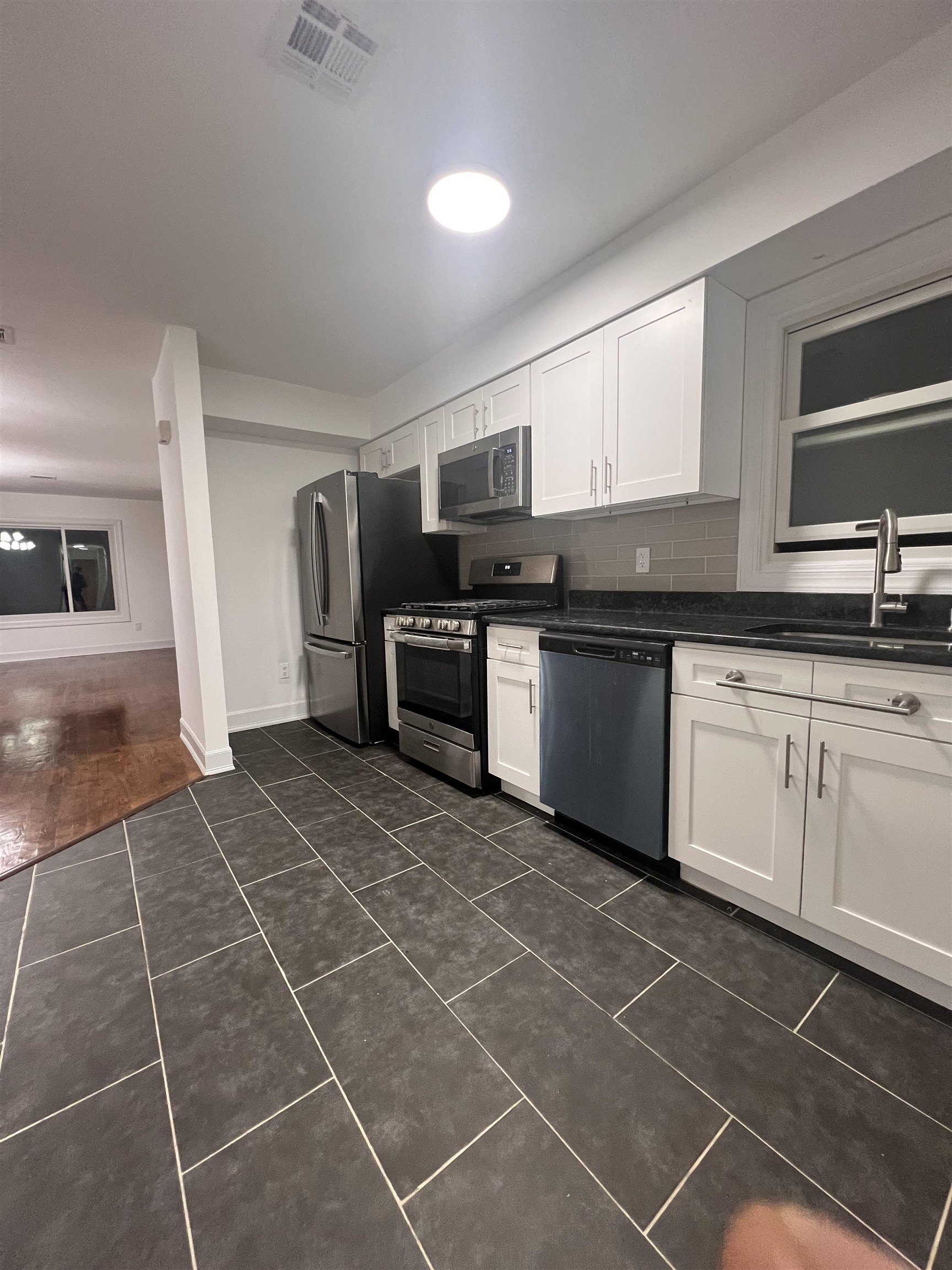 1302 Morris Street Union City, NJ 07087 - Photo 10 of 12 a kitchen with stainless steel appliances a sink a stove a microwave a counter top space and cabinets