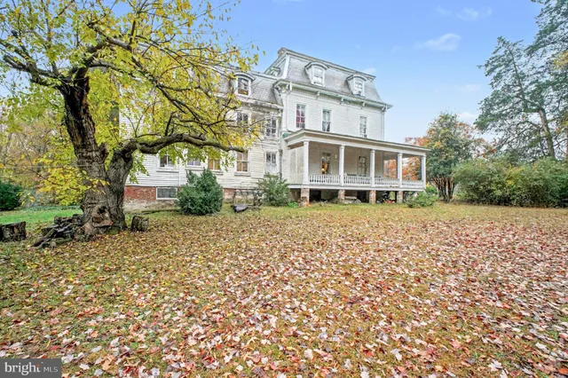 a view of residential houses with yard and trees