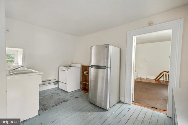 a view of a refrigerator in kitchen and a wooden floor