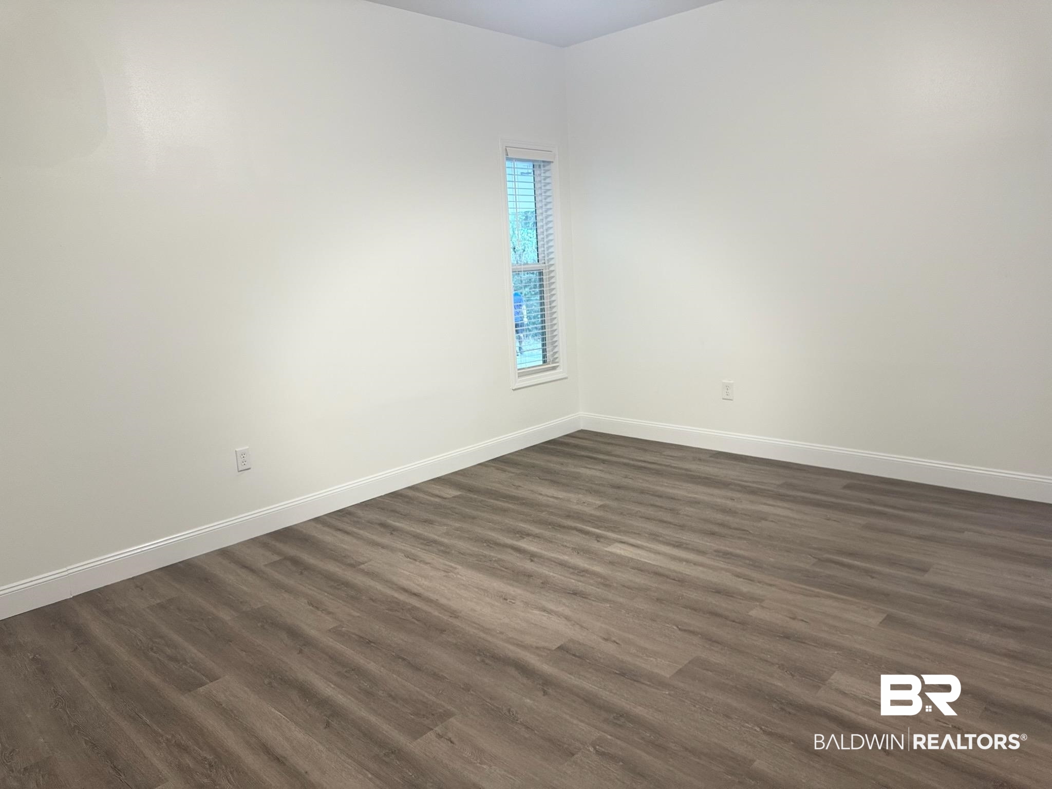 2663 Demetropolis Road Mobile, AL 36693 - Photo 23 of 26 Empty room with dark wood-style floors and baseboards