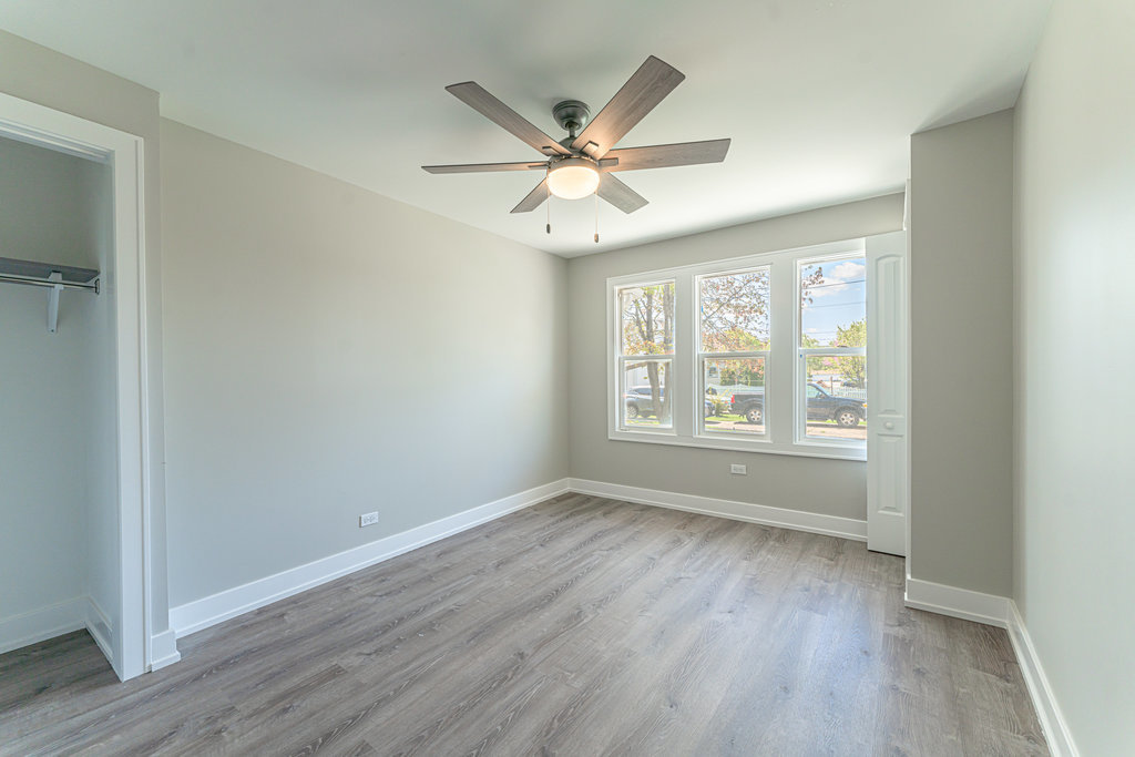 2330 121st Street Blue Island, IL 60406 - Photo 22 of 33 an empty room with wooden floor fan and windows