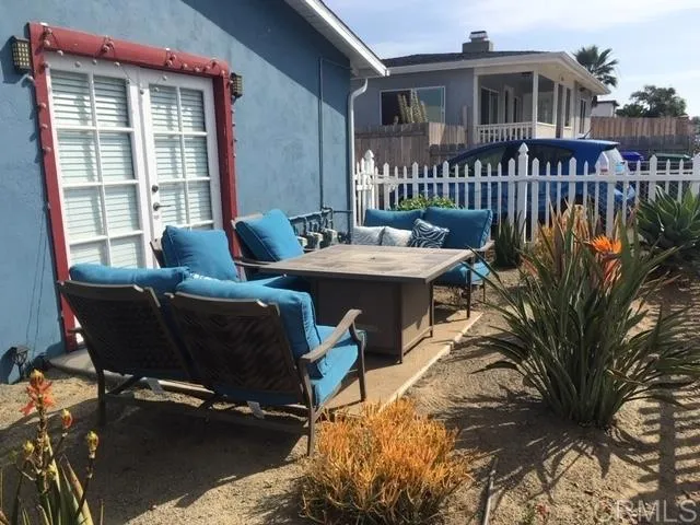 a roof deck with table and chairs and potted plants