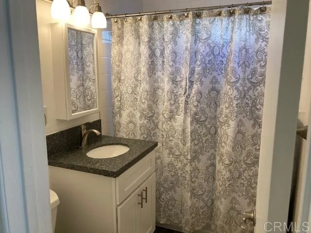 1402 Dubuque Street Oceanside, CA 92058 - Photo 11 of 21 a bathroom with a granite countertop sink and a mirror