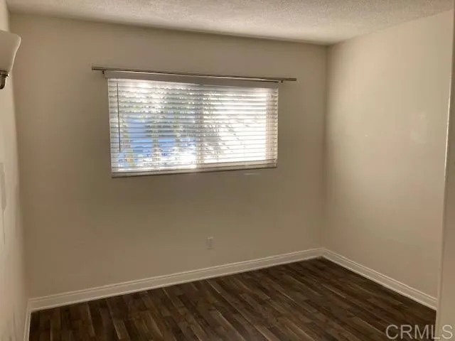 1402 Dubuque Street Oceanside, CA 92058 - Photo 13 of 21 a view of an empty room with wooden floor and a window