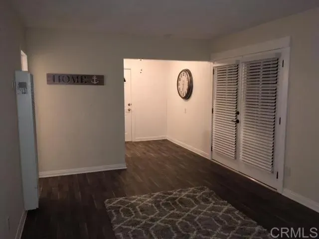 a view of empty room with wooden floor and floor to ceiling window