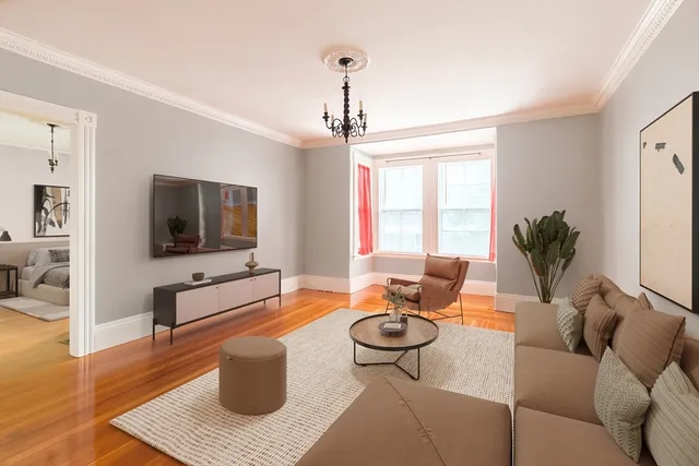 a living room with furniture a flat screen tv and a window