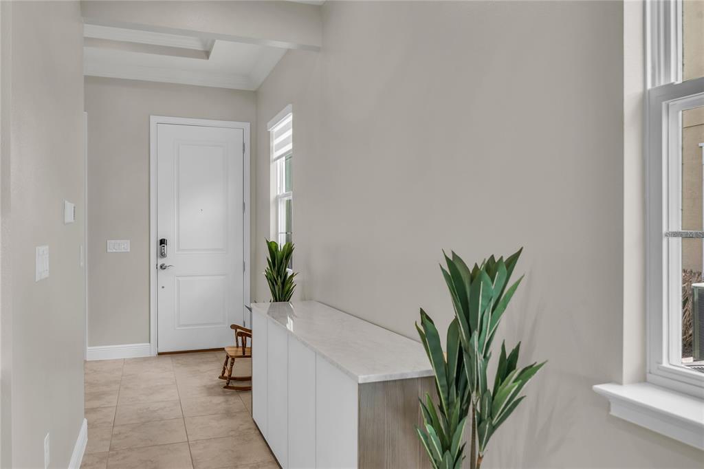 2665 Meadowedge Loop St. Cloud, FL 34772 - Photo 7 of 53 a hallway with a potted plant on a table and a window