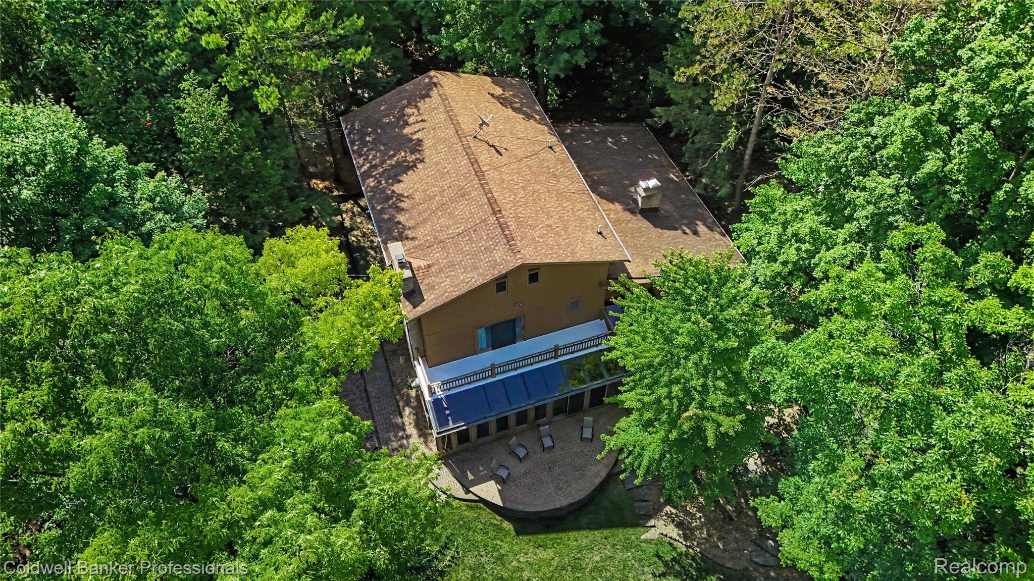 3583 Mitchell Road Metamora, MI 48455 - Photo 57 of 58 Private property surrounded by mature trees, featuring a multi-level structure with a shingle roof