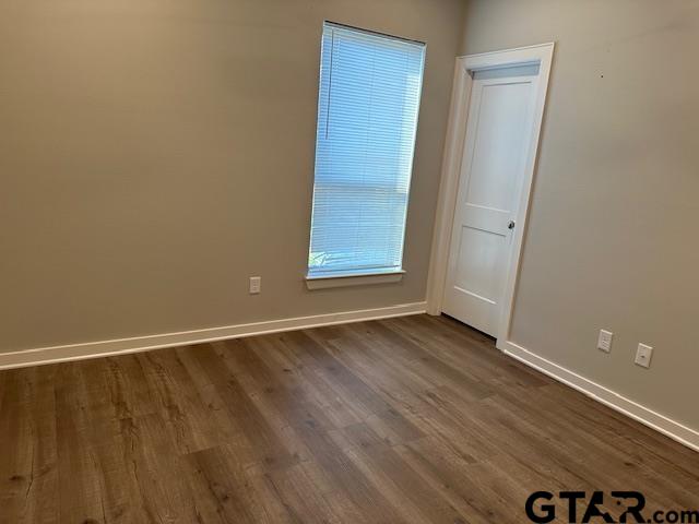 16461 County Road 178, Unit 2 Tyler, TX 75703 - Photo 14 of 16 an empty room with wooden floor and windows