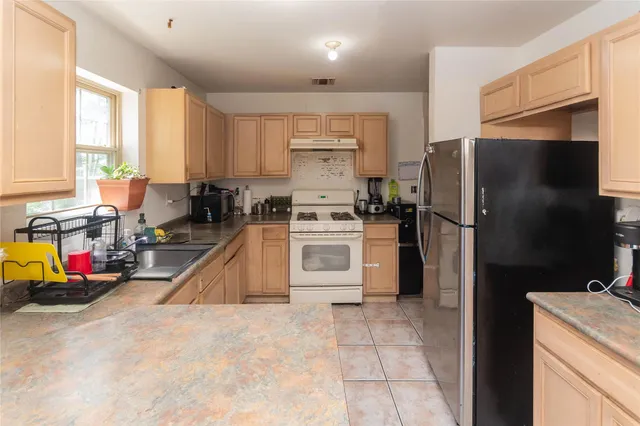 a kitchen with stainless steel appliances granite countertop a stove a refrigerator and a refrigerator