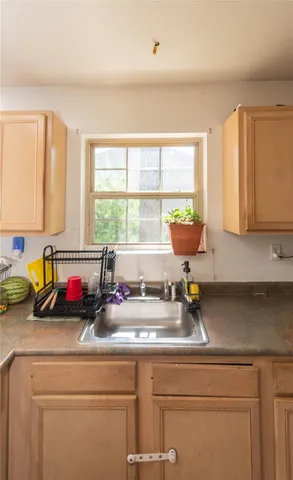 a kitchen with a stove a sink and a granite counter tops with white cabinets