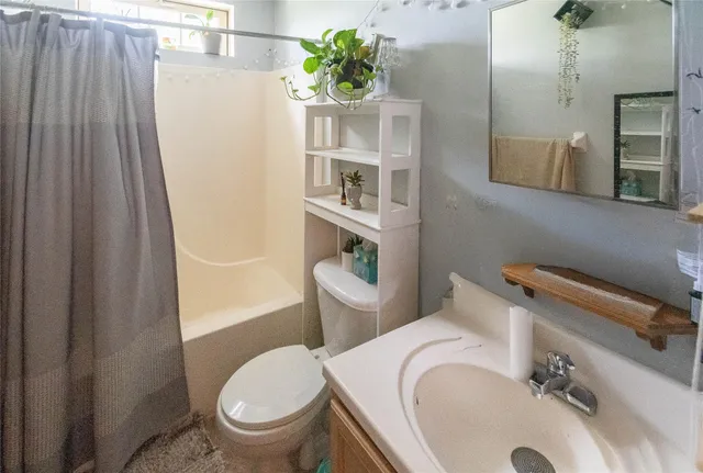 a white toilet sitting next to a bathroom sink and tub