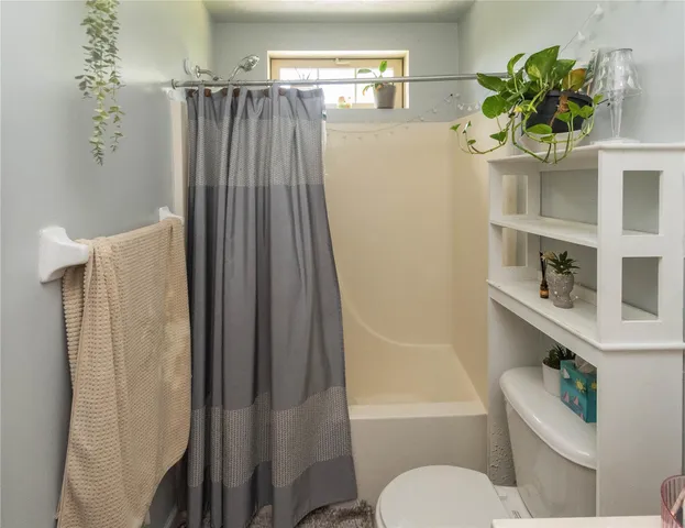 a bathroom with a shower curtain and a toilet