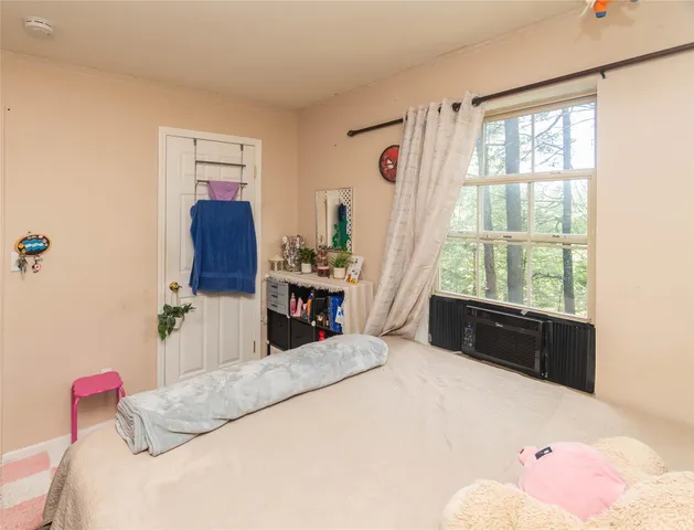 a bedroom with a bed dresser and a window