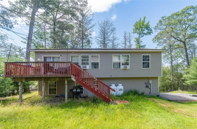 a view of a house with pool and chairs in a yard