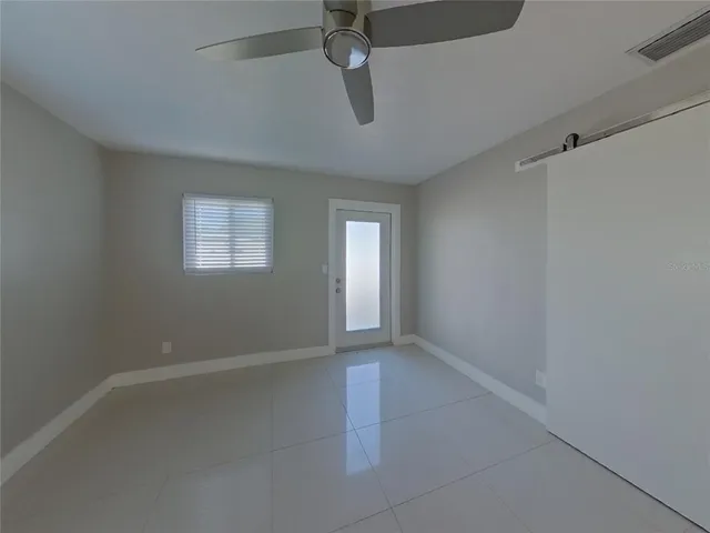 an empty room with windows and fan