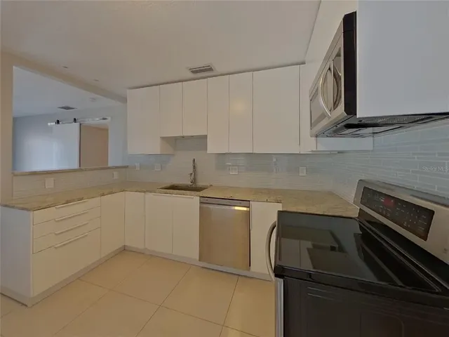 a kitchen with a sink stove and cabinets