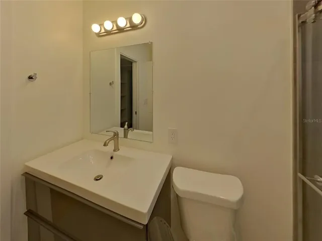 a bathroom with a sink a toilet and a mirror