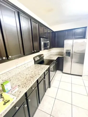 a kitchen with granite countertop a sink a stove and a wooden floor