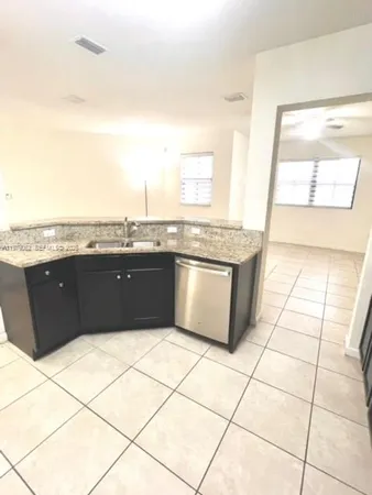 a kitchen with granite countertop a stove a sink and a granite counter tops