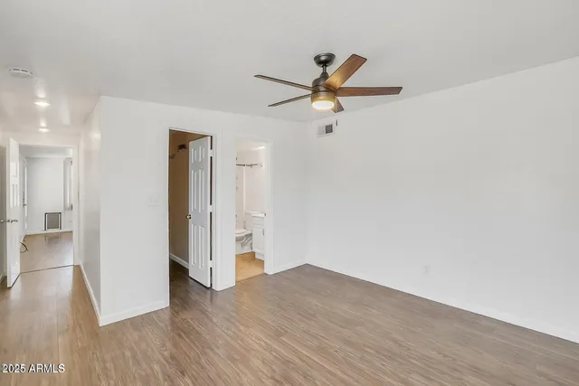 a view of a livingroom with wooden floor and a ceiling fan