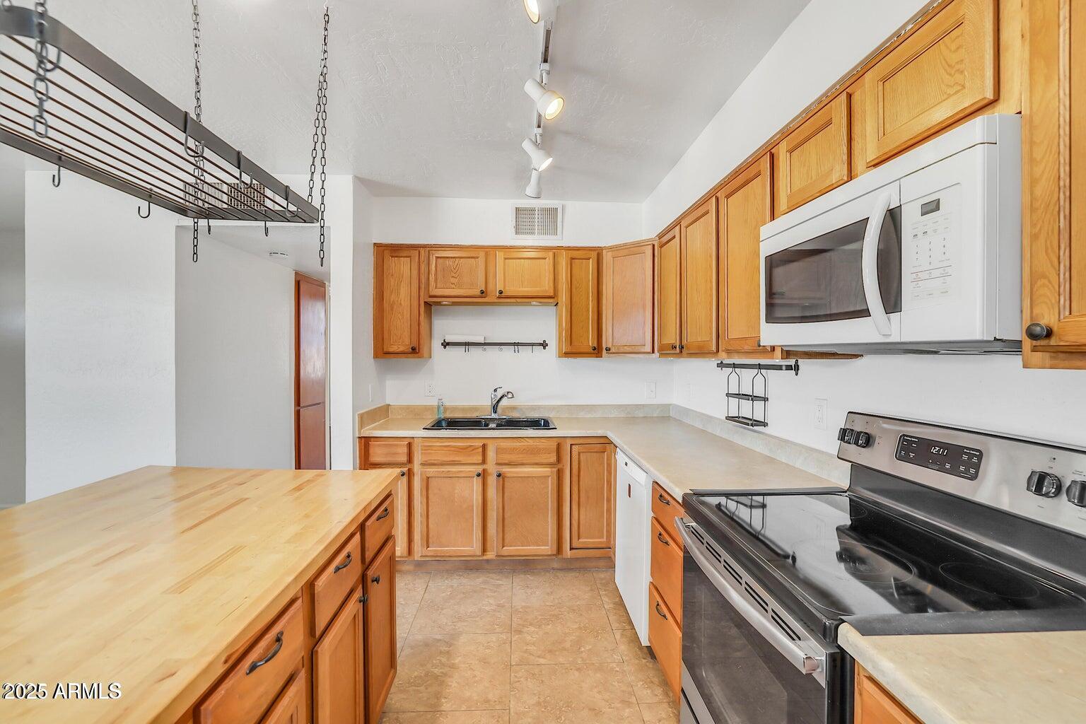 1526 West Huntington Drive Tempe, AZ 85282 - Photo 3 of 17 a kitchen with stainless steel appliances a stove sink microwave and cabinets